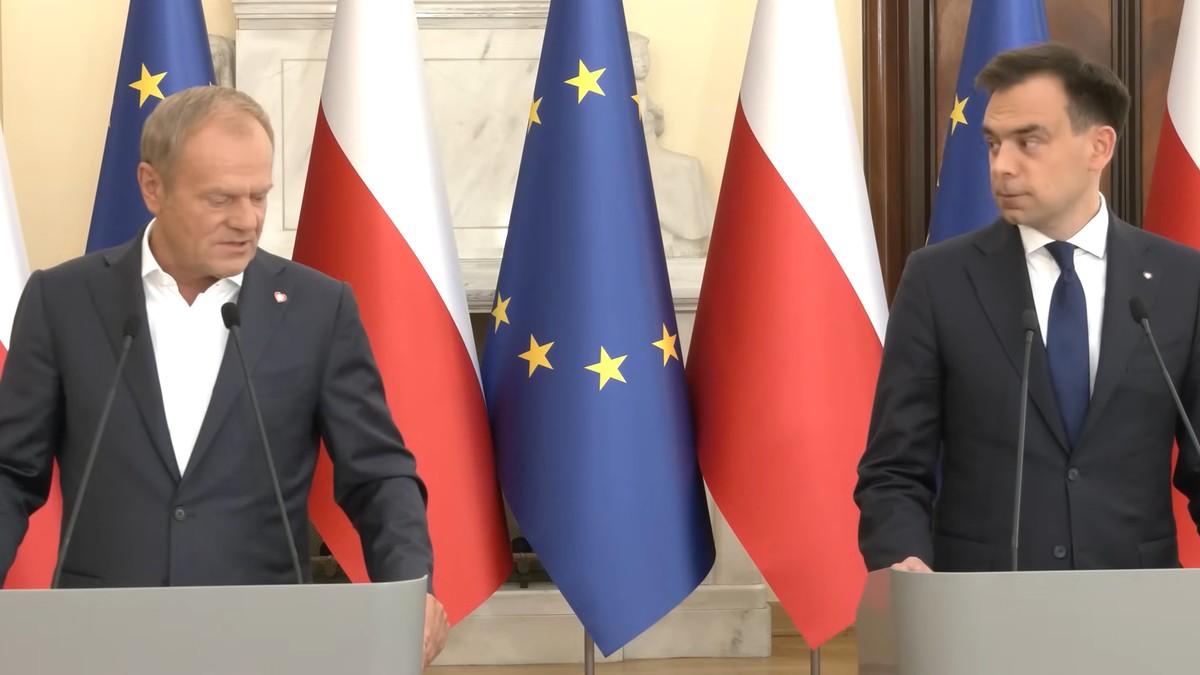 Donald Tusk i Andrzej Domański na tle flag Polski i Unii Europejskiej