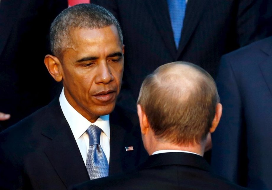 US President Barack Obama shakes hands with Russia's President Vladimir Putin (back to camera) as they gather for a family photo with fellow world leaders at the start of the G20 summit at the Regnum Carya Resort in Antalya, Turkey, November 15, 2015.