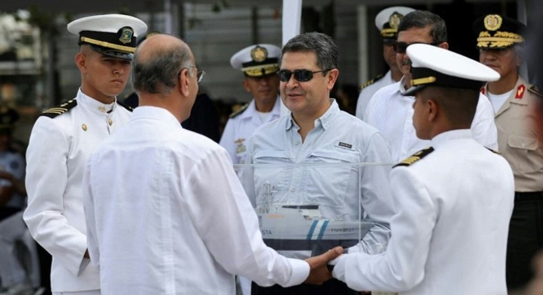 Honduran President Juan Orlando Hernandez (C), shown at the handover ceremony for a coastal patrol vessel bought from Israel, has dismissed as absurd accusations that he received bribes from drug lords