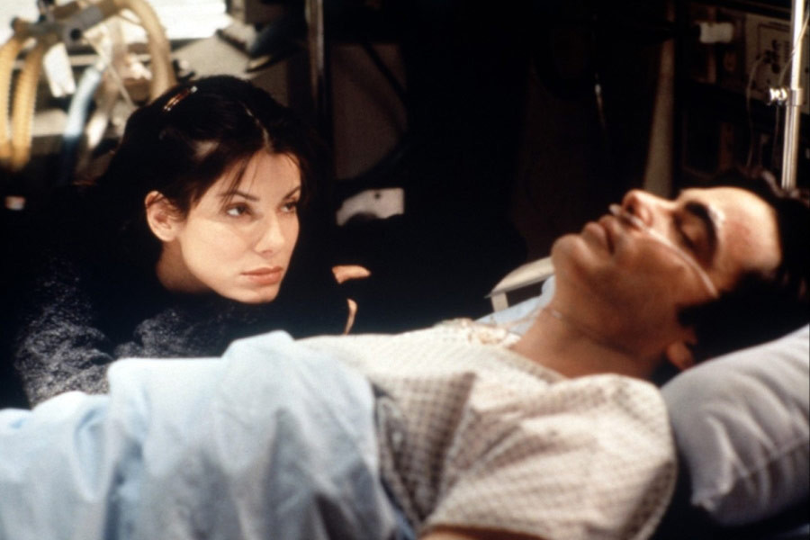 Sandra Bullock jako Lucy Eleanor Moderatz w filmie "Ja cię kocham, a ty śpisz" (1995). Na zdjęciu także Peter Gallagher 