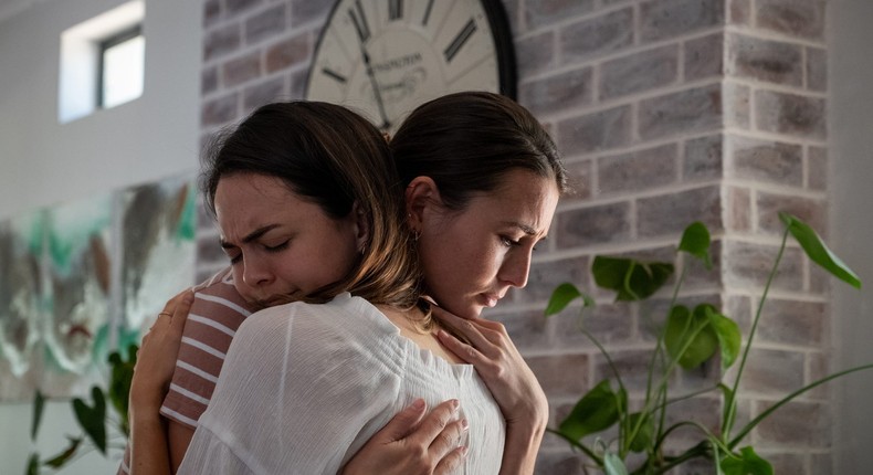 A woman comforts her friend with an embrace.nattrass/Getty Images