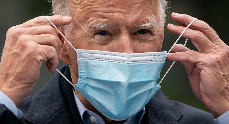 President Joe Biden puts on a face mask while speaking to reporters on October 26, 2020 in Chester, Pennsylvania.
