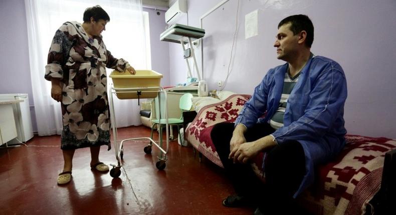 Ukranian woman Olena Gorbatova (L), plays with her baby as her husband Sergiy (R) looks on at the maternity hospital in the war-torn eastern city of Avdiivka.