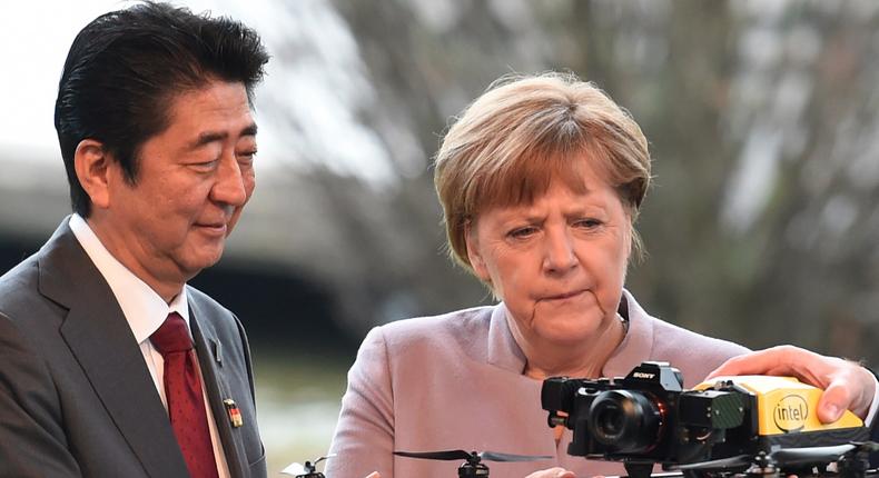 Japanese Prime Minister Shinzo Abe and German Chancellor Angela Merkel with a drone at a media tour of the world's biggest computer and software fair, CeBit, in Hanover, Germany.