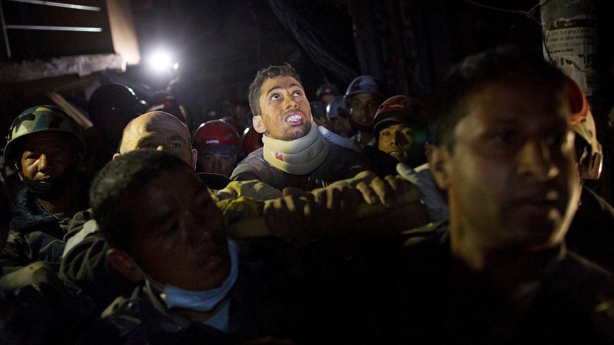 Rishi Khanal, an injured survivor, is carried on a stretcher by Nepali police after being rescued by French rescue teams from a damaged building following Saturday's earthquake in Kathmandu