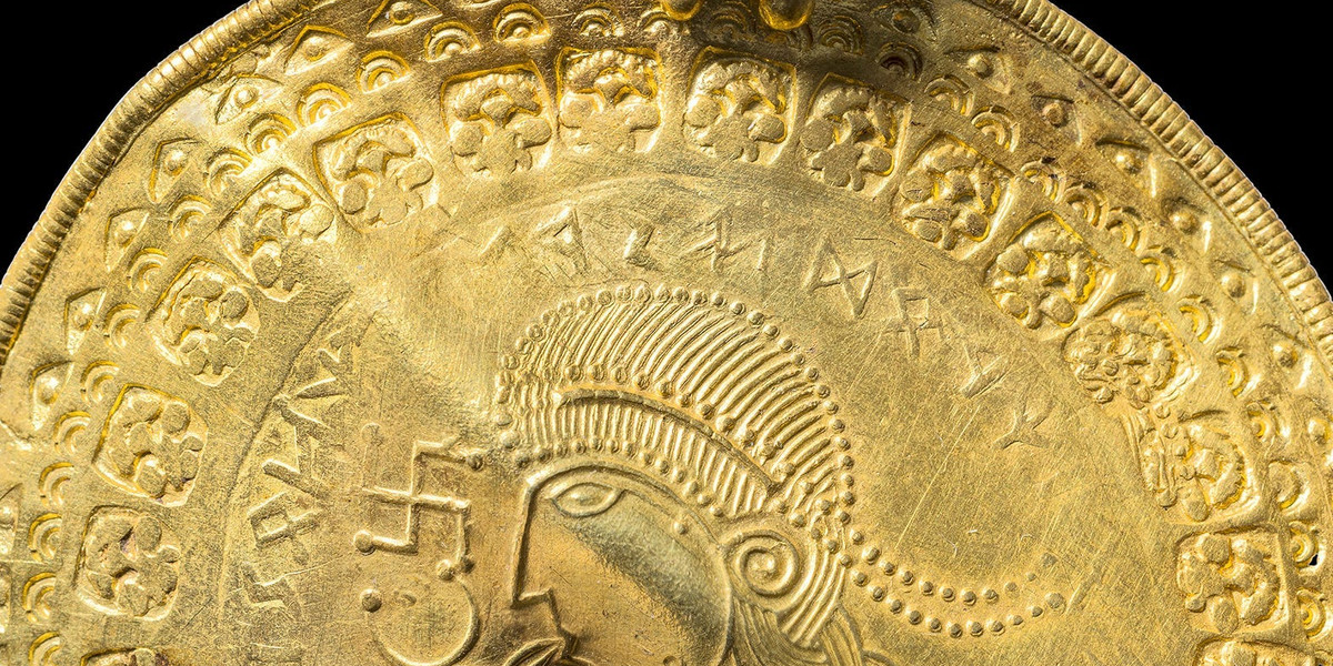 Starożytny złoty krążek przedstawiający najstarszy na świecie napis odnoszący się do nordyckiego boga Odyna.  
