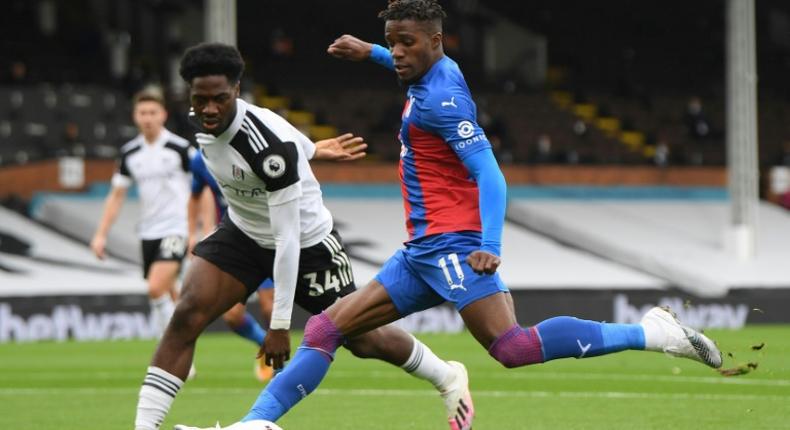 Fulham defender Ola Aina fails to prevent Crystal Palace winger Wilfried Zaha (R) unleashing a shot