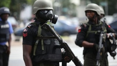 A Nigerian police officer wearing a gas mask