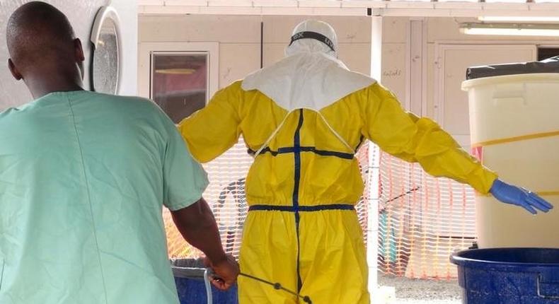 A health worker gets sprayed with disinfectant in an Ebola virus treatment center in Conakry, Guinea, November 17, 2015.  REUTERS/Saliou Samb/Files