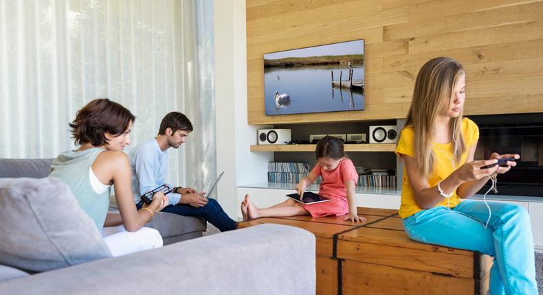 Family in living room working on electronics