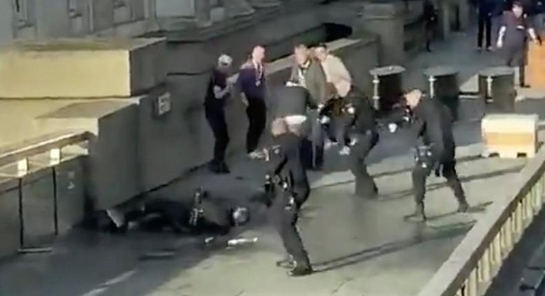 In this grab taken from video made available by @HLOBlog, a man is surrounded by police after an incident on London Bridge, in London, Friday, Nov. 29, 2019. A man wearing a fake explosive vest stabbed several people before being tackled by members of the public and then shot dead by armed officers on London Bridge, police and the city's mayor say. Police say they are treating it as a terrorist attack. (@HLOBlog via AP)