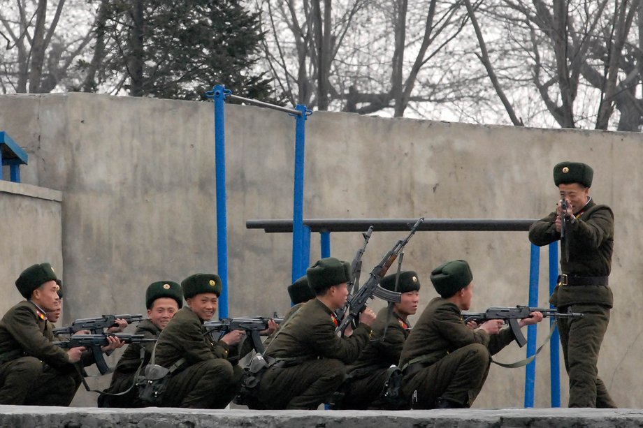 A North Korean soldier points his gun at the photographer.