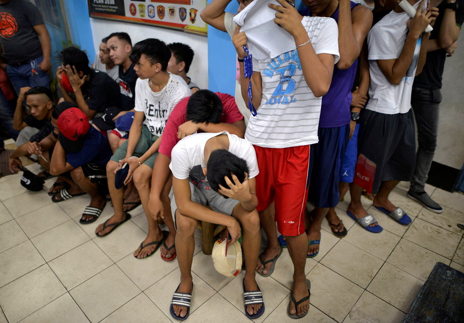 People wait to be processed at a police station after they were detained in a police "One Time Bigtime" operation against illegal drugs in metro Manila, Philippines, October 12, 2016.