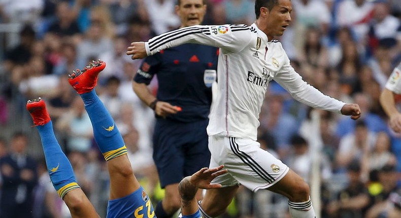 Real Madrid's Cristiano Ronaldo (R) runs past Valencia's Nicolas Otamendi on the ground during their Spanish first division soccer match at Santiago Bernabeu stadium in Madrid, Spain, May 9, 2015.  REUTERS/Paul Hanna      TPX IMAGES OF THE DAY