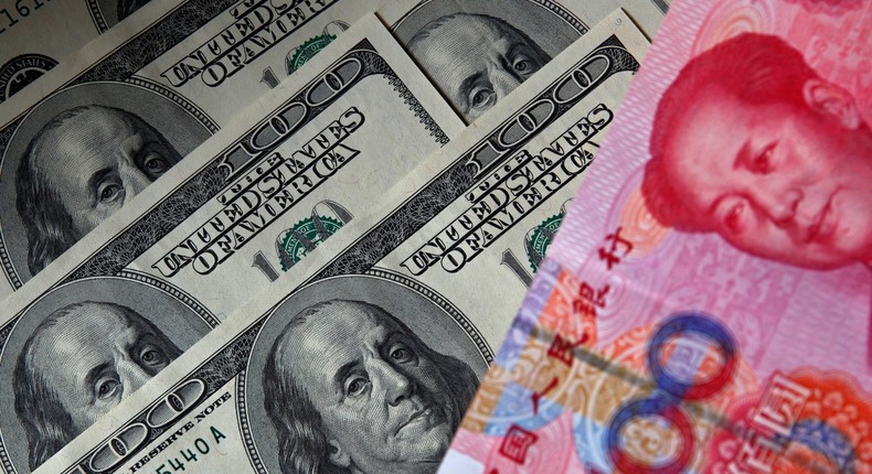 A 100 yuan banknote (R) is placed next to $100 banknotes in this picture illustration taken in Beijing Nov. 1, 2010.Reuters/Petar Kujundzic