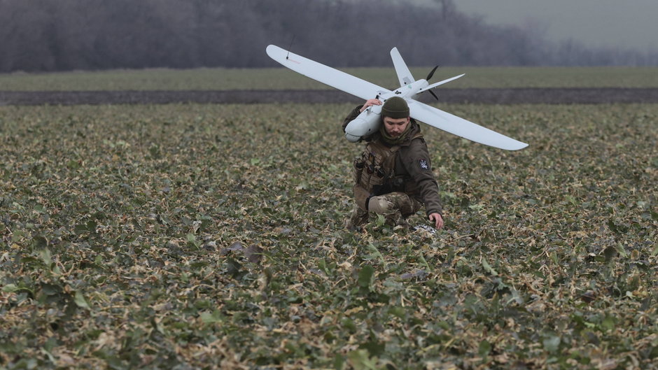 Żołnierz ze 108. brygady obrony terytorialnej niesie dron Leleka-100 w pobliżu frontu zaporoskiego, 15 lutego 2024 r.