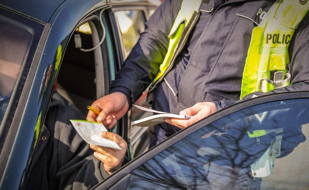 Policjant wypisuje mandat