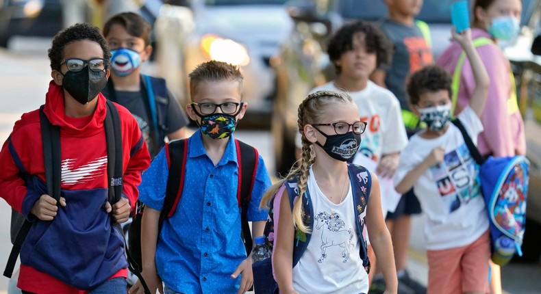 In this Tuesday, Aug. 10, 2021 file photo, Students, some wearing protective masks, arrive for the first day of school at Sessums Elementary School in Riverview, Fla.
