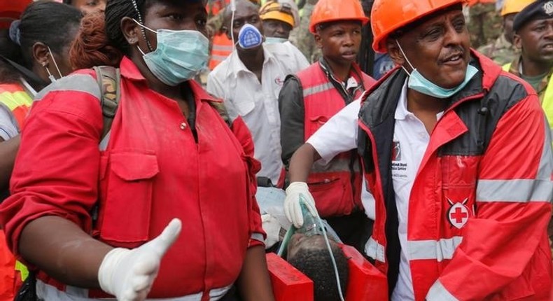 Kenya Red Cross rescuers evacuate a woman from the rubble of a six-storey building that collapsed last Friday after days of heavy rain, in Nairobi, Kenya May 5, 2016. 