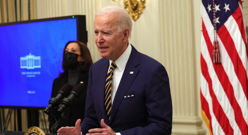 President Joe Biden speaks as Vice President Kamala Harris looks on during an event on economic crisis in the State Dining Room of the White House January 22, 2021 in Washington, DC.