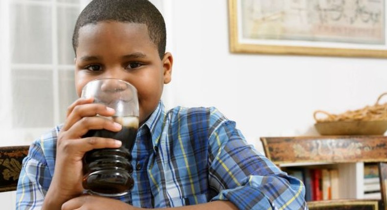 Young boy drinking soda