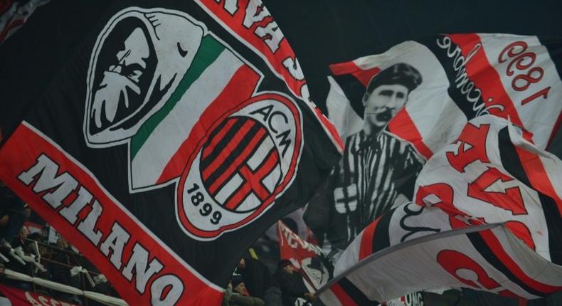 AC Milan supporters wave flags during a serie A match against Juventus