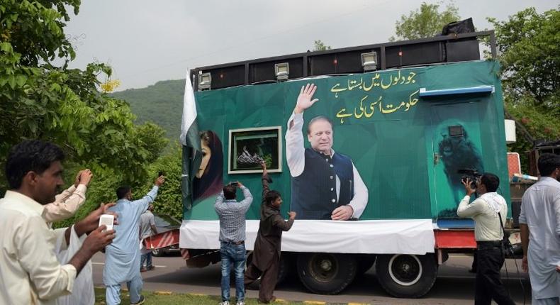 Pakistani supporters of deposed prime minister Nawaz Sharif gather around a container prepared for the rally led by Sharif in Islamabad
