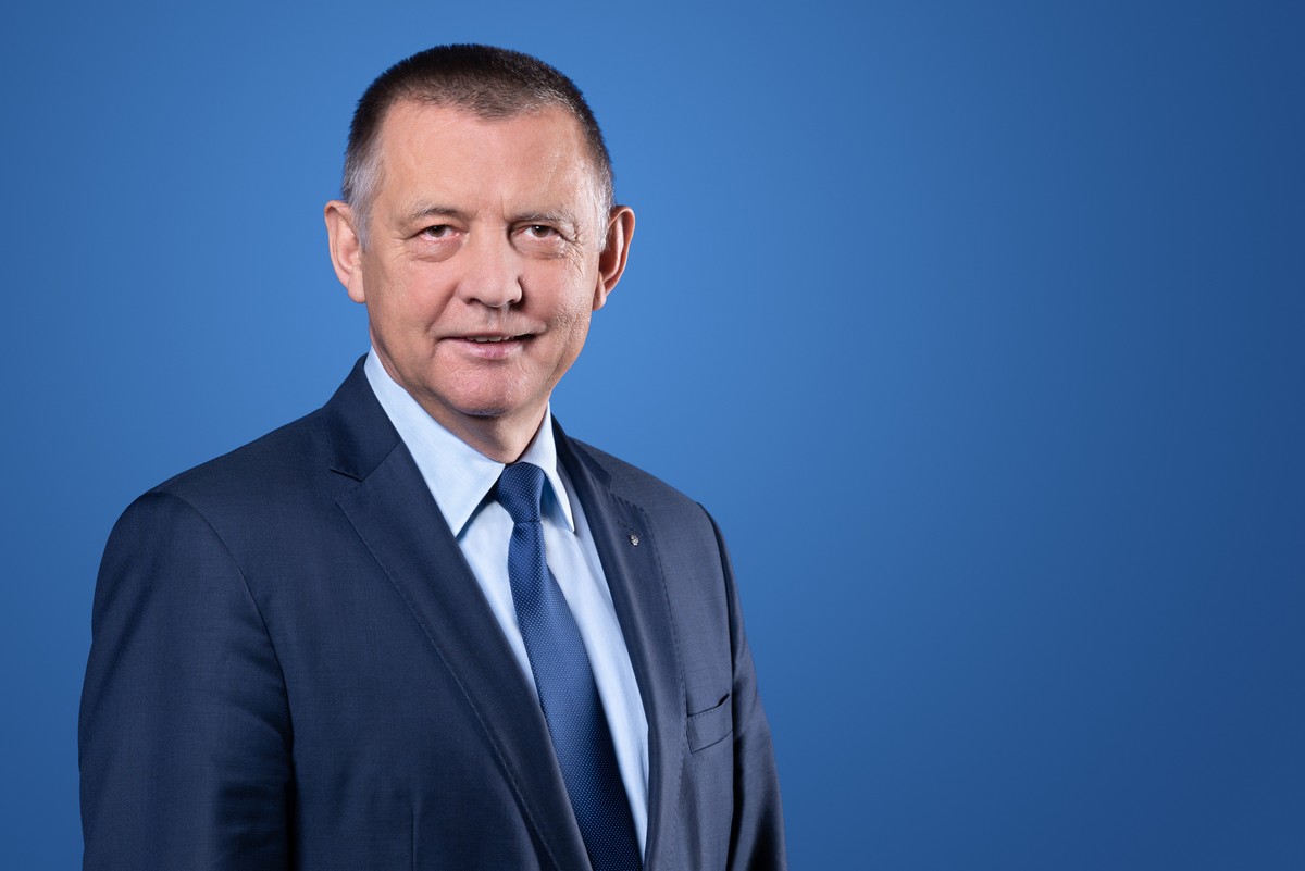 Prezes Najwyższej Izby Kontroli (NIK) Marian Banaś na niebieskim tle