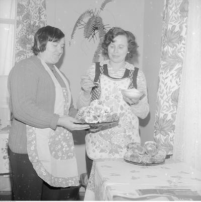 Koło Gospodyń Wiejskich w Proboszczowicach. Janina Dąbrowska i Krystyna Niekłań posypują cukrem pączki. 1975 rok.