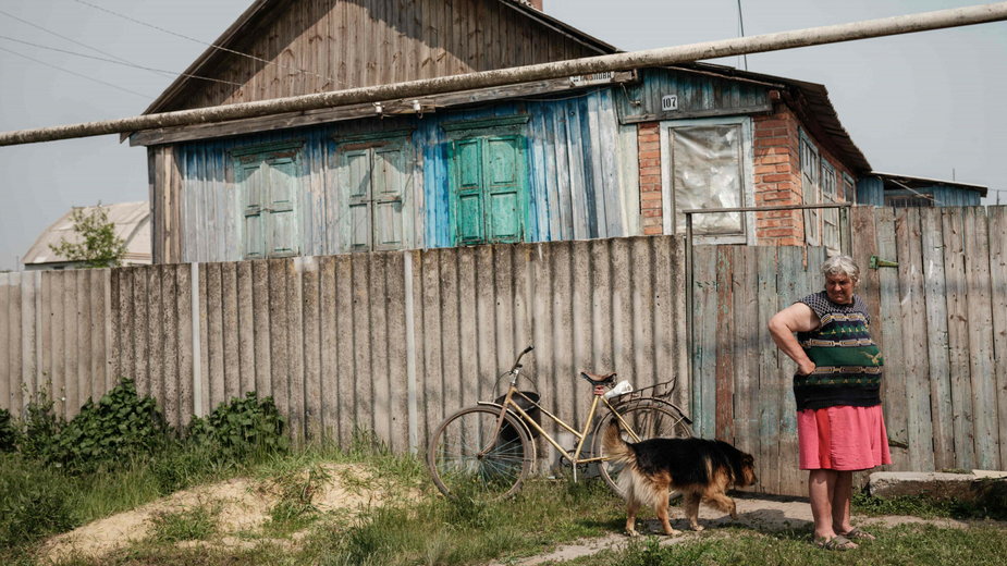 61-letnia Liubow Baidykowa stojąca z psem przed swoim domem w Siewiersku (zdjęcie ilustracyjne)