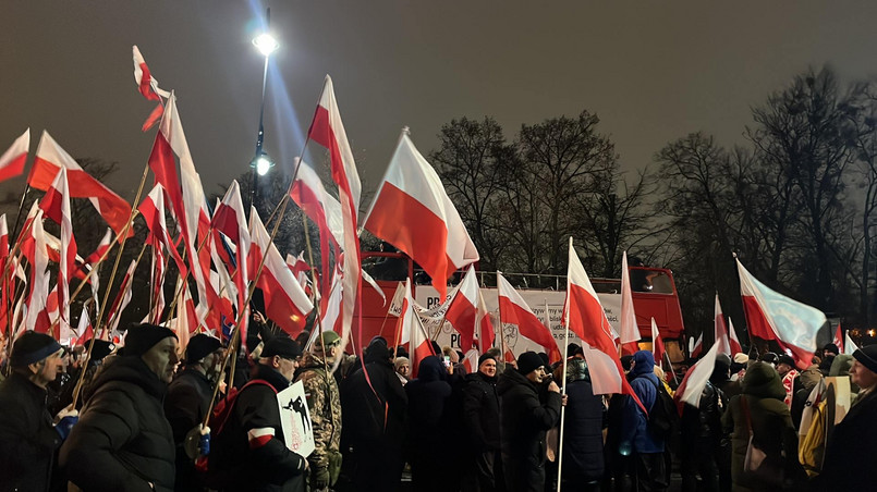 Flagi Polski powiewające nad uczestnikami marszu