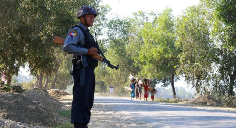 An armed Myanmar police officer is posted on the road during the arrival of the UN special rapporteur on Myanmar in Buthidaung, northern Rakhine State on January 14, 2017