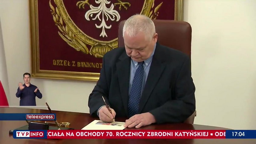 Prezes NBP Adam Glapiński podpisujący banknot