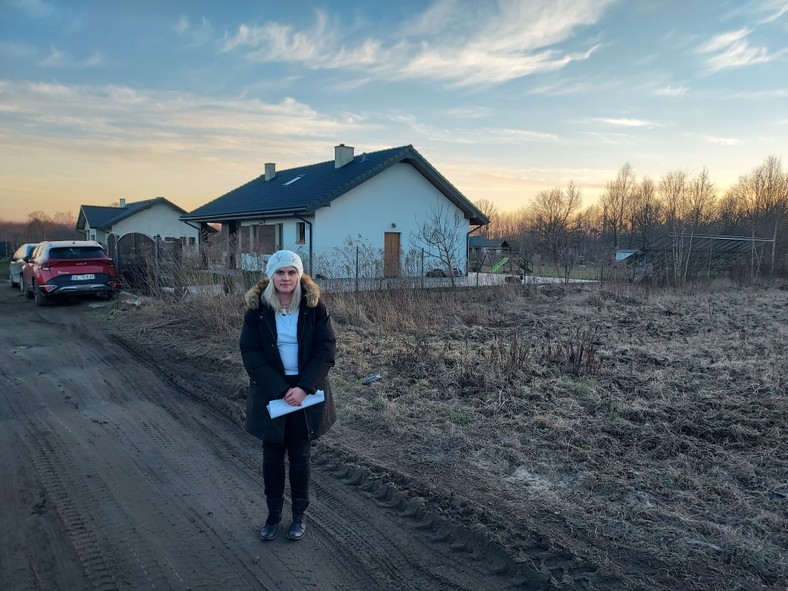 Katarzyna Hołys-Lewy przed swoim domem w Mileszkach, za nim posesja jej bliźniaczki