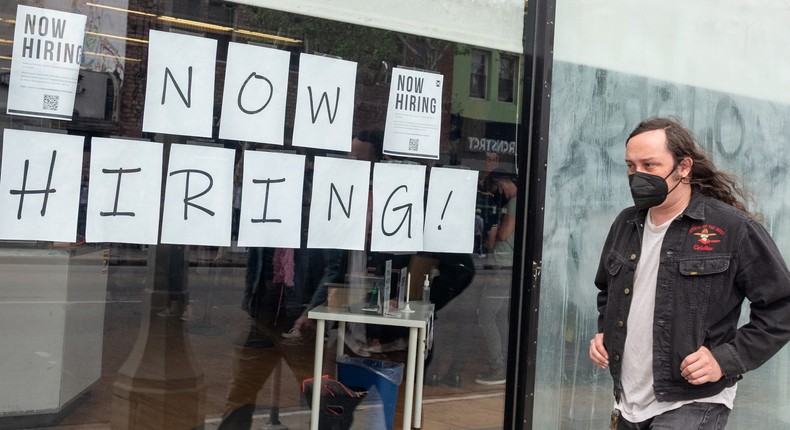 A man wearing a mask walks past a now hiring sign on Melrose Avenue amid the coronavirus pandemic on April 22, 2021 in Los Angeles, California.
