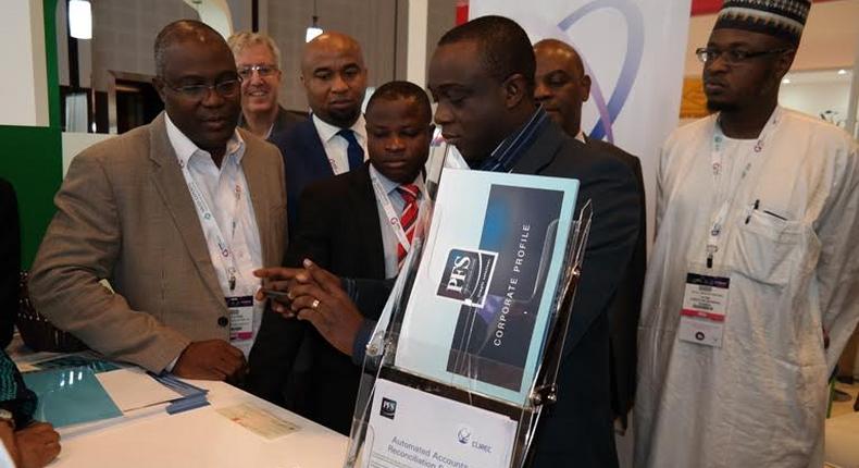 MD/CEO, Precise Financial Systems [PFS], [middle] demonstrates how the iTeller Mobile Cheque Truncations works while Deputy MD, PFS, Philips Ayeni (left), President, Nigeria Computer Society [NCS] Prof. Sola Aderonmu, [second left) and Director General, National Information Technology Development Agency [NITDA] Dr. Isa Ali Ibrahim (Pantami) pay attention at the launch ceremony at GITEX 2016 in Dubai on Monday  .