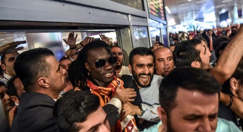 French forward Bafetimbi Gomis (centre) is escorted outside the Ataturk International airport as he is greeted by fans upon his arrival, on June 28, 2017 in Istanbul