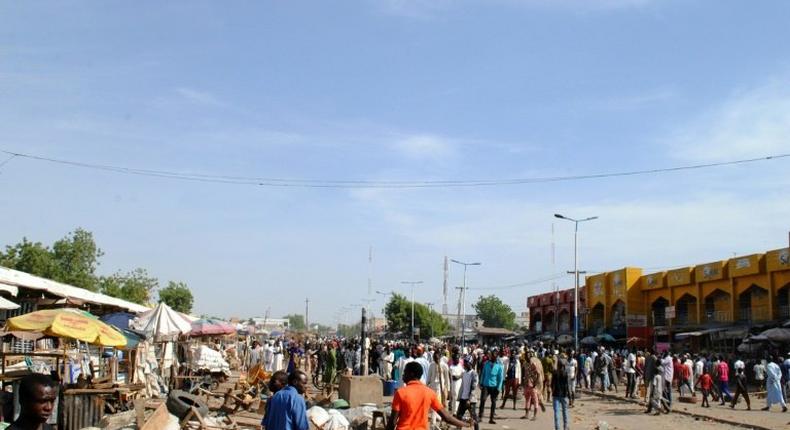 Residents gather near the scene of a suicide bomb attack on a market in Maiduguri, after two young girls blew themselves up, killing themselves and wounding at least 17 others, in December 2016