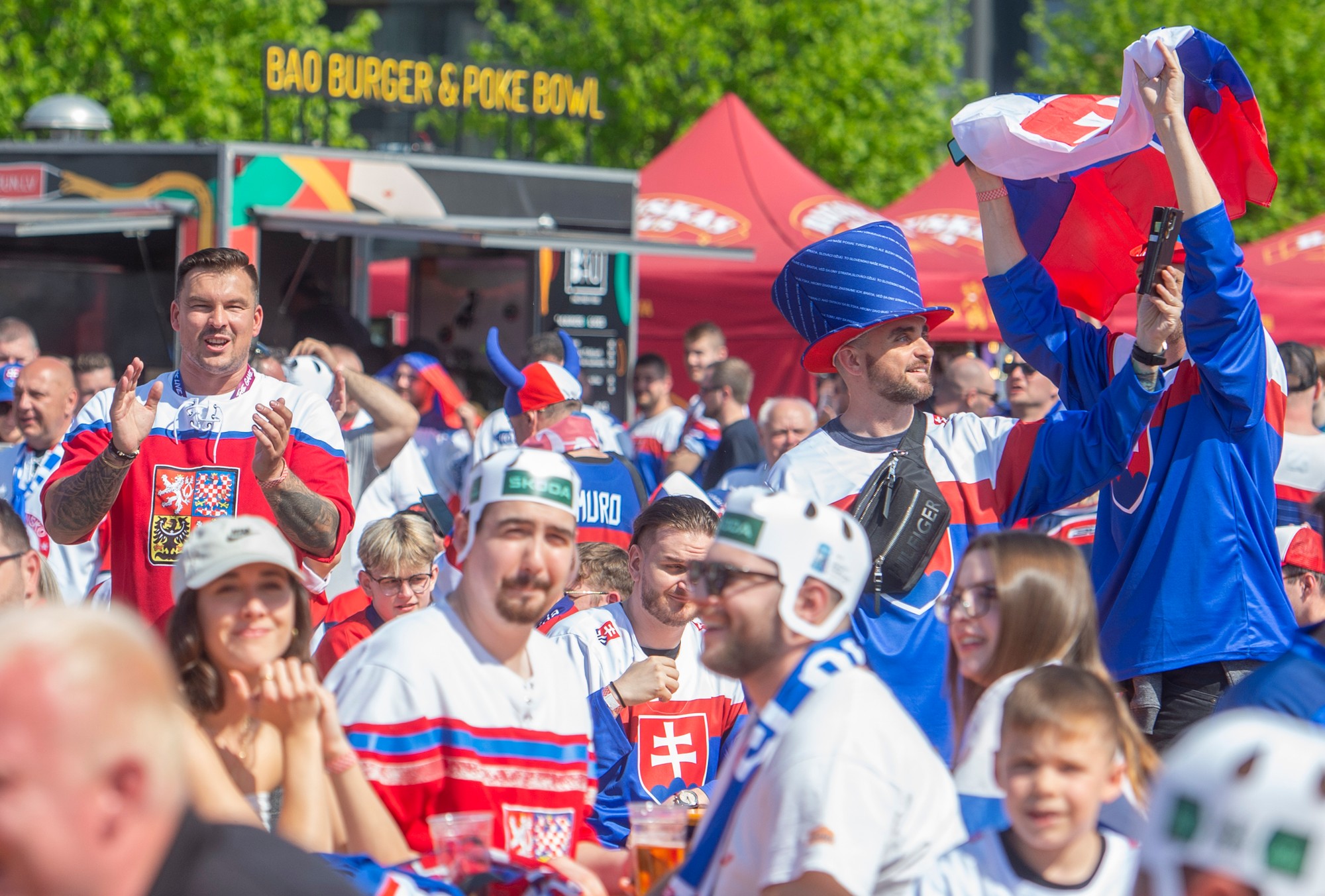 Slovenskí a českí fanúšikovia pózujú pred Riga Arénou pred prvým zápasom na MS v hokeji 2023.