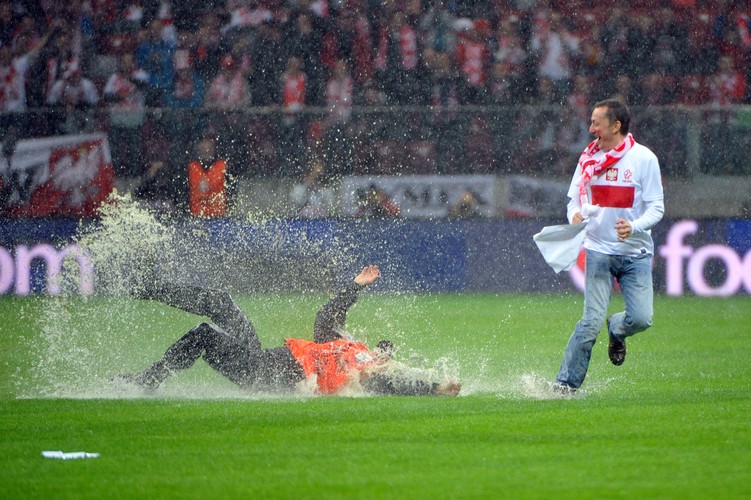 Polski kibic i ochrona w pościgu na zalnym wodą boisku