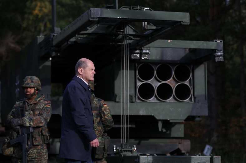 Kanclerz Niemiec Olaf Scholz obok wielorakietowego systemu rakietowego (MLRS) Bundeswehry podczas wizyty na poligonie w północnych Niemczech, 17 października 2022 r.