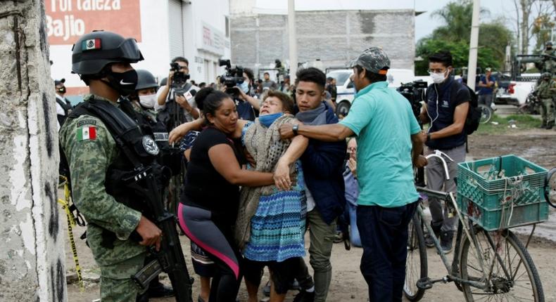 A woman reacts near the crime scene where 24 people were killed in Irapuato, Guanajuato state, Mexico