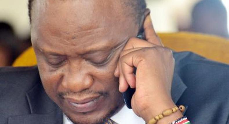 President Uhuru Kenyatta using a mobile phone