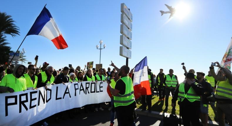 Protestors hold a banner reading The people speak out during a protest of 'yellow vests' against rising fuel prices and living costs, in the southern French city of Nice on December 8, 2018