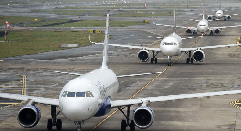 Planes wait in line on a runway for take-off.PUNIT PARANJPE/AFP via Getty Images