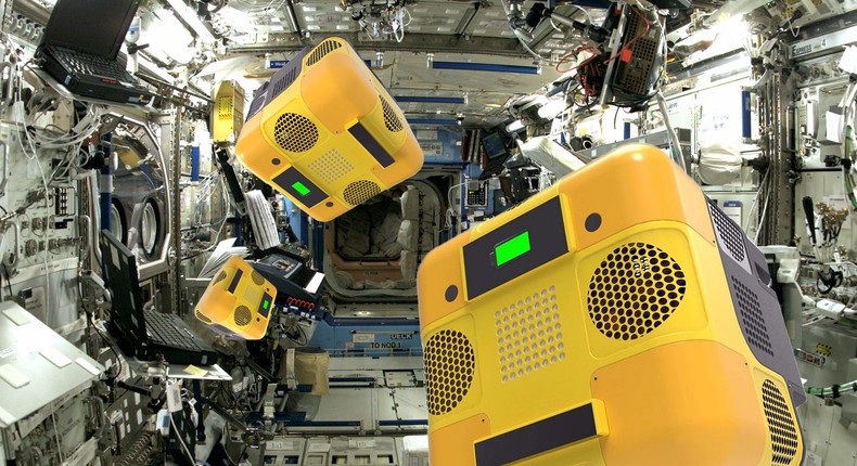 An illustration of Astrobee robots floating around the International Space Station.