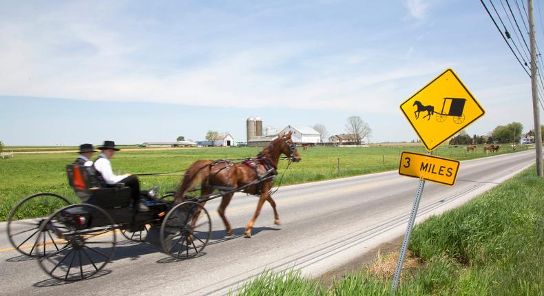 Amish men driving a horse and buggy on a country road.Grant Faint/Getty Images