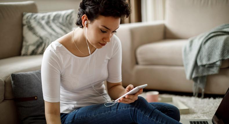 Young woman watching streaming shows on phone at home