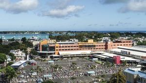 An aerial shot taken in April 2020 shows people waiting while adhering to social distancing in a parking lot before entering a supermarket in Grand Baie, Mauritius; the country has declared wary victory over the coronavirus