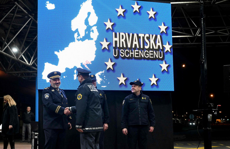 Policjanci podający sobie ręce w pobliżu punktu kontroli celnej, na przejściu granicznym między Chorwacją a Słowenią, 1 stycznia 2023 r.